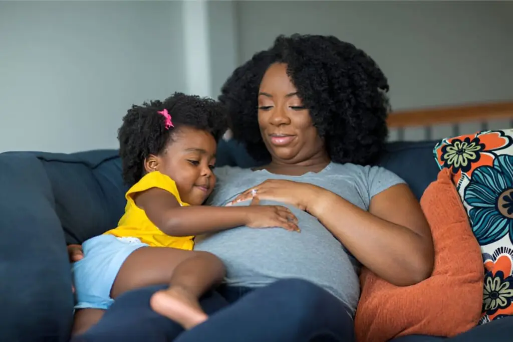 Femme enceinte utilisant le savon noir Nigeria — soin naturel sans risque pour bébé