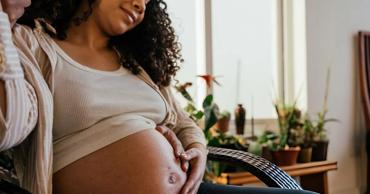 Femme enceinte africaine adoptant une routine douce au savon noir Nigeria Naija Store avec prudence et conseil médical